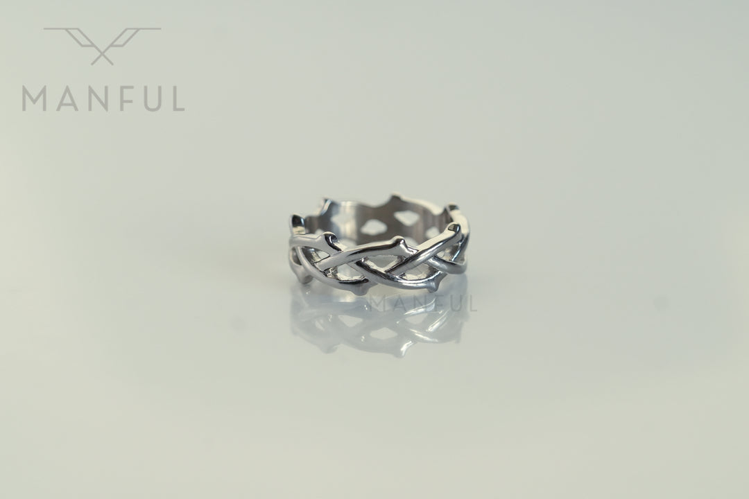 Thorn Ring Silver, lying flat on a pale surface with its reflection visible