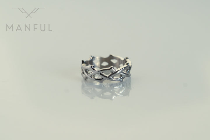 Thorn Ring Silver, lying flat on a pale surface with its reflection visible