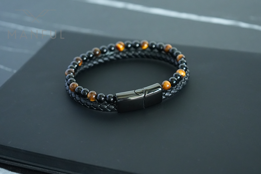 Tigers Eye Bead And Leather Bracelet, laid open on a dark stone surface showing the full loop
