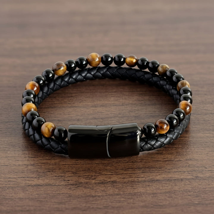 Tigers Eye Bead And Leather Bracelet lying in an open loop on a walnut table