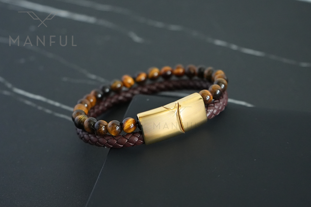 Tigers Eye Bead And Leather Bracelet Gold, flat lay on dark marble with the beaded strand curving across the top