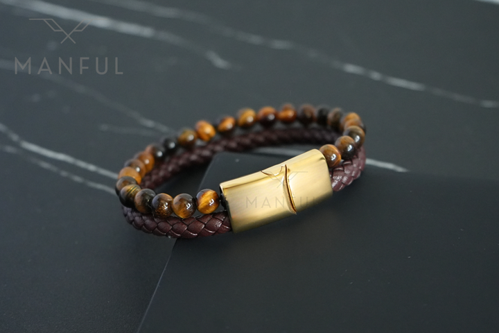 Tigers Eye Bead And Leather Bracelet Gold, flat lay on dark marble with the beaded strand curving across the top