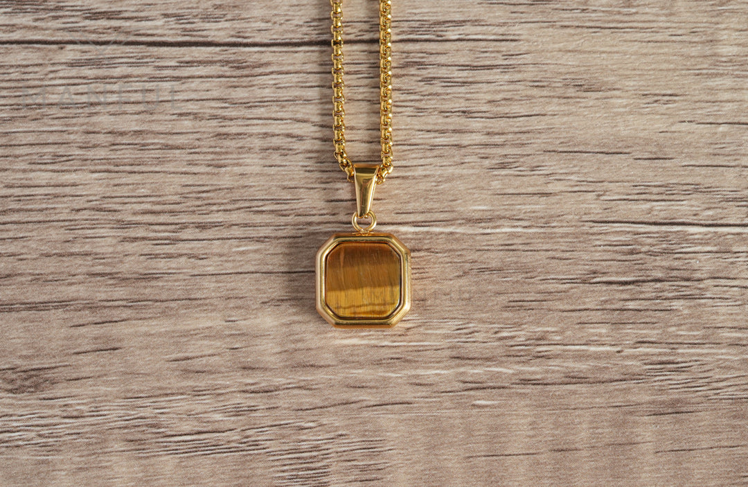 Tigers Eye Square Necklace Gold, a flat lay close-up on a wood table showing the stone's grain