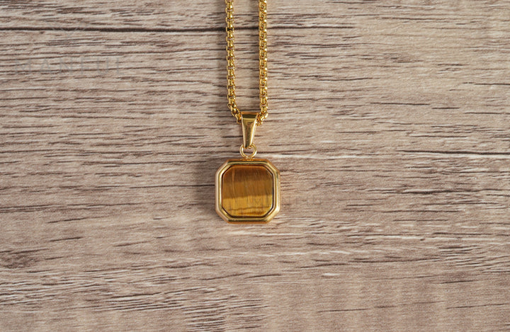 Tigers Eye Square Necklace Gold, a flat lay close-up on a wood table showing the stone's grain