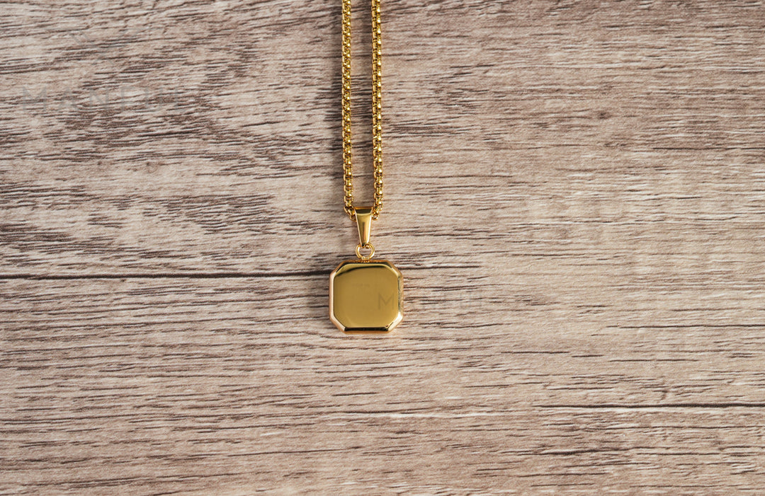 Tigers Eye Square Necklace Gold, a flat lay showing the plain engravable gold back on a wood table