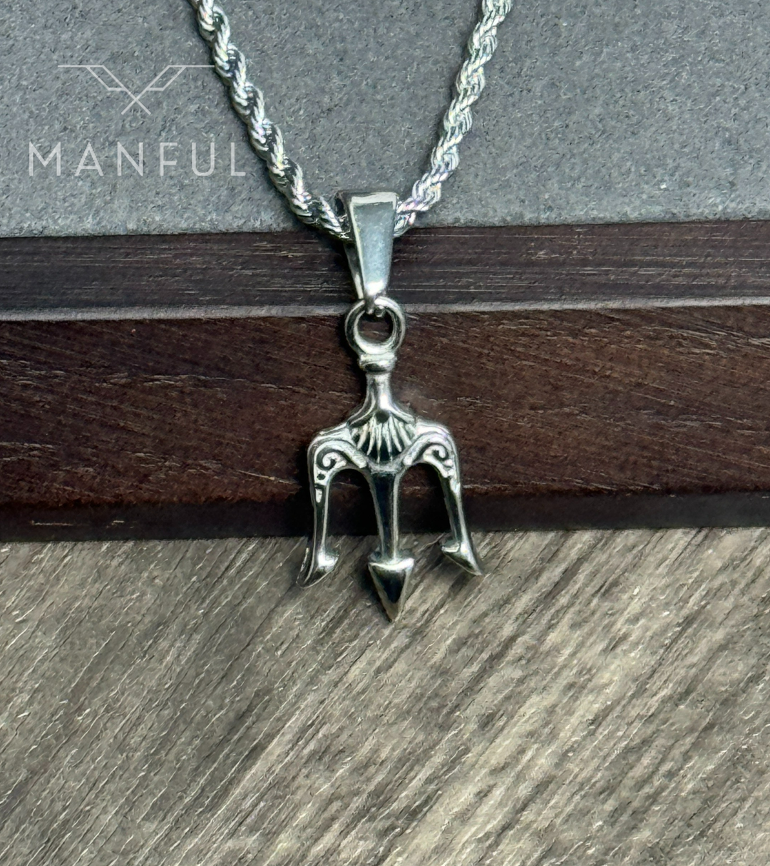 Trident Pendant Necklace Silver, close-up leaning against a dark wood block