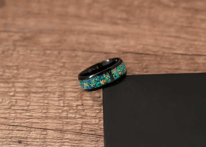 Trinity Opal Ring, leaning against a black block on a wood surface