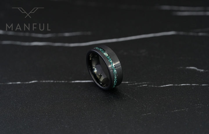 Tungsten Aquamarine Inlay Band Black, tilted on dark marble revealing the inner band and teal stone inlay