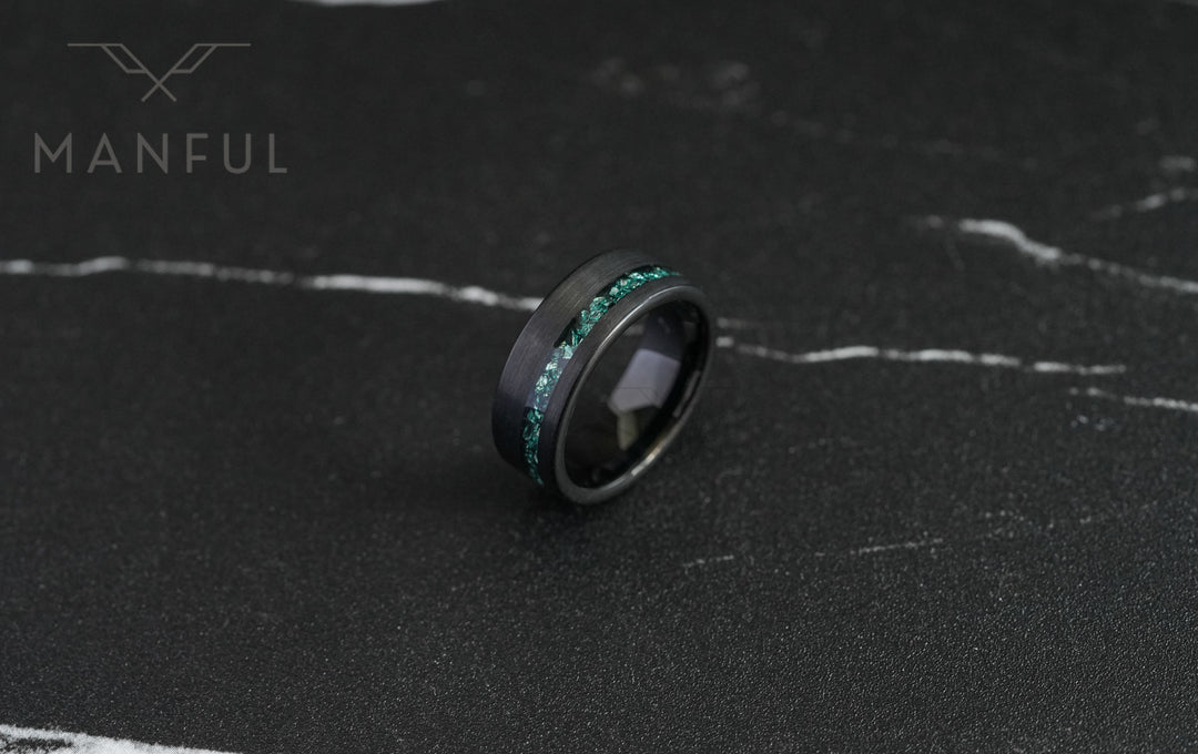 Tungsten Aquamarine Inlay Band Black, resting on dark marble at a slight angle showing the teal inlay