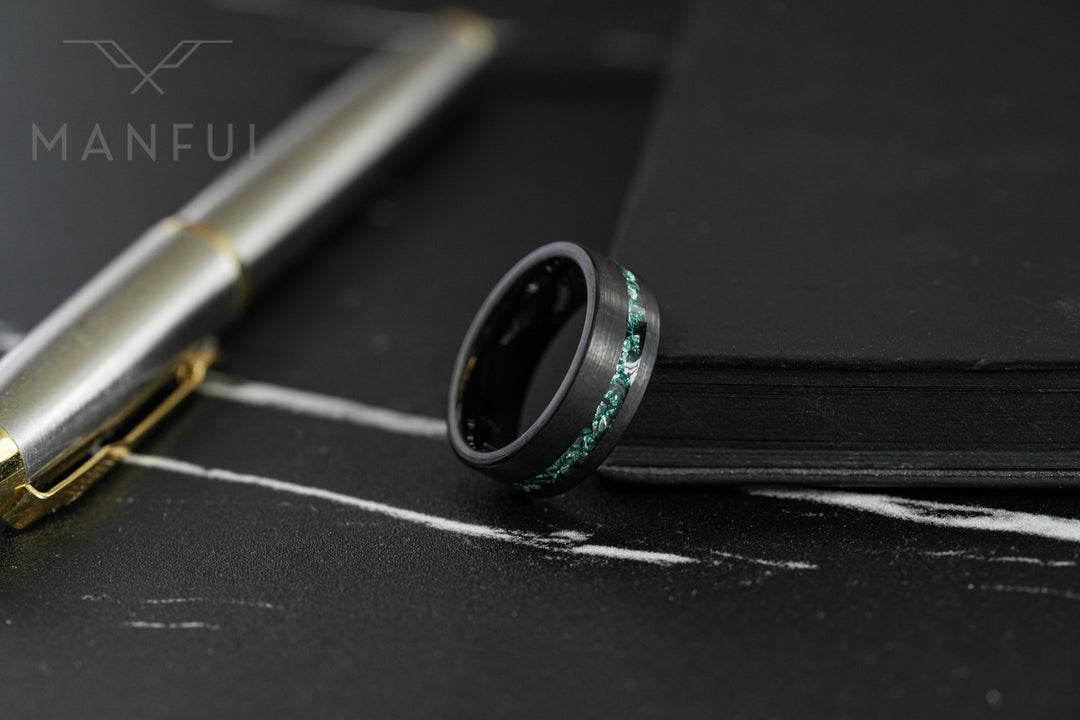 Tungsten Aquamarine Inlay Band Black, propped against a pen on dark slate