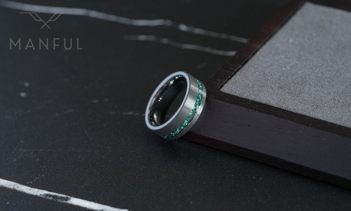 Tungsten Aquamarine Inlay Band Silver, leaning against a wooden block on a dark surface