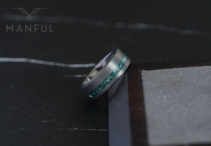 Tungsten Aquamarine Inlay Band Silver, wedged into a wooden block corner with the bore facing camera