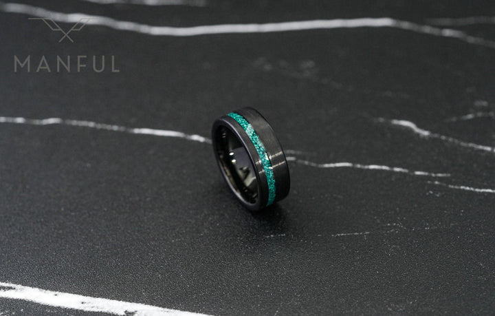 Tungsten Malachite Inlay Band Black, tilted on its side on dark marble viewed from a low angle
