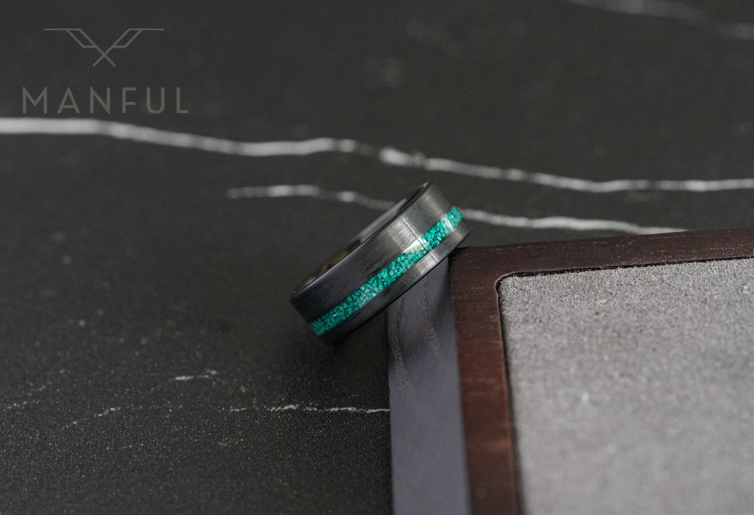 Tungsten Malachite Inlay Band Black, close-up against a wooden box showing the malachite inlay