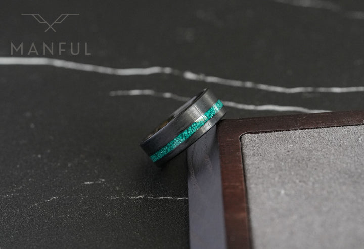 Tungsten Malachite Inlay Band Black, close-up against a wooden box showing the malachite inlay