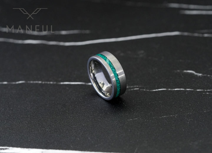 Tungsten Malachite Inlay Band Silver, standing upright on a dark marble surface with white veining