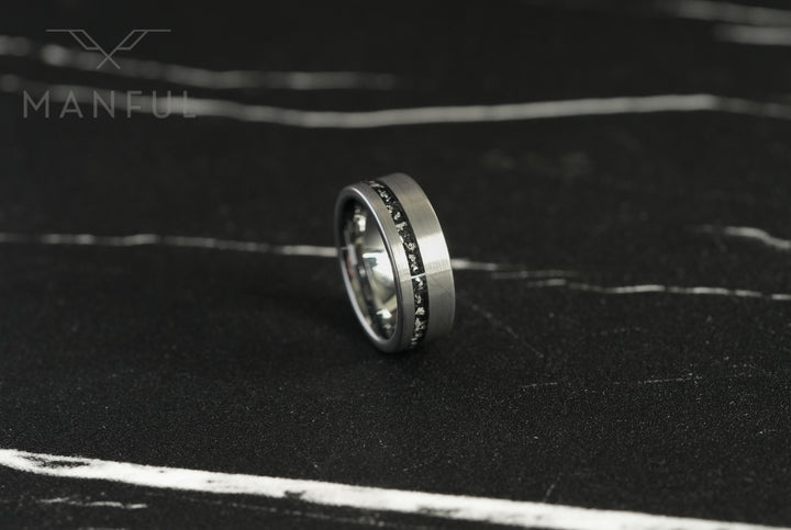 Tungsten Meteorite Inlay Band Silver, standing on a dark marble surface at an angle