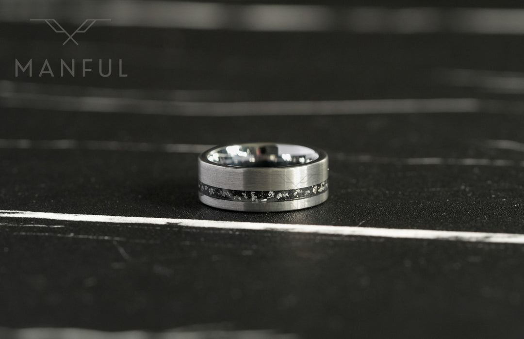 Tungsten Meteorite Inlay Band Silver, close-up on a dark marble surface with a blurred backdrop