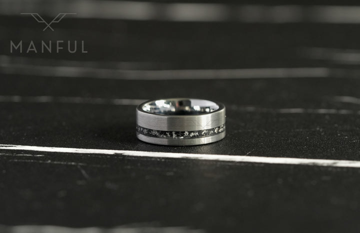 Tungsten Meteorite Inlay Band Silver, close-up on a dark marble surface with a blurred backdrop