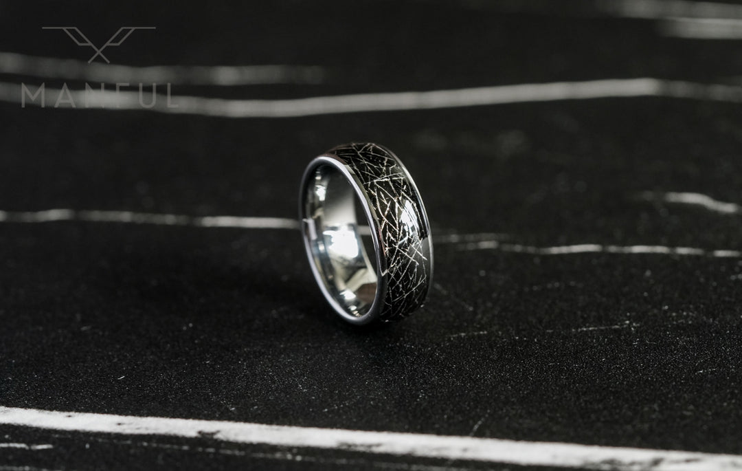 Meteorite Fragment Ring, standing upright on dark slate with the polished silver interior visible