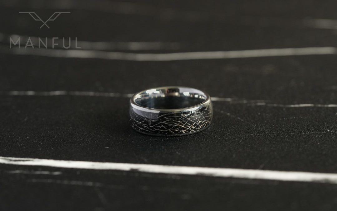 Meteorite Fragment Ring, lying tilted on dark slate with a close view of the cracked texture