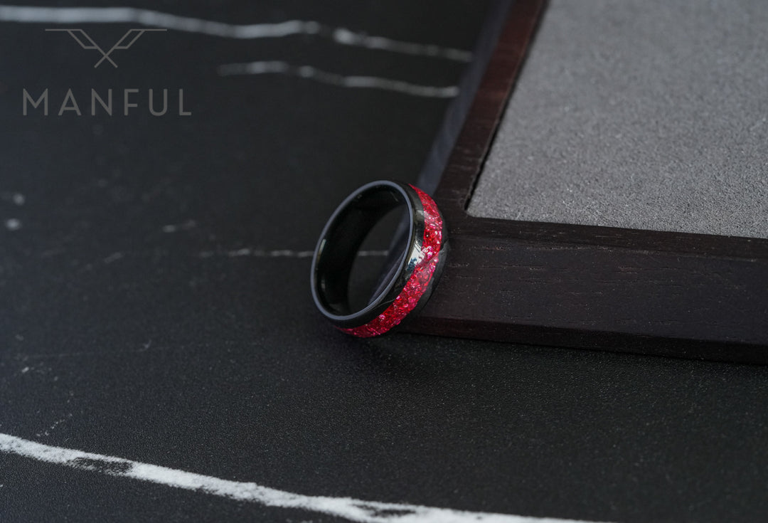 Tungsten Red Opal Black Band, propped against a dark wooden block edge on a black textured surface