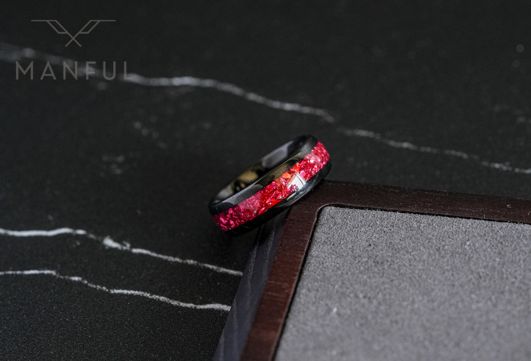 Tungsten Red Opal Black Band, leaning against a wooden block corner on a dark marble surface