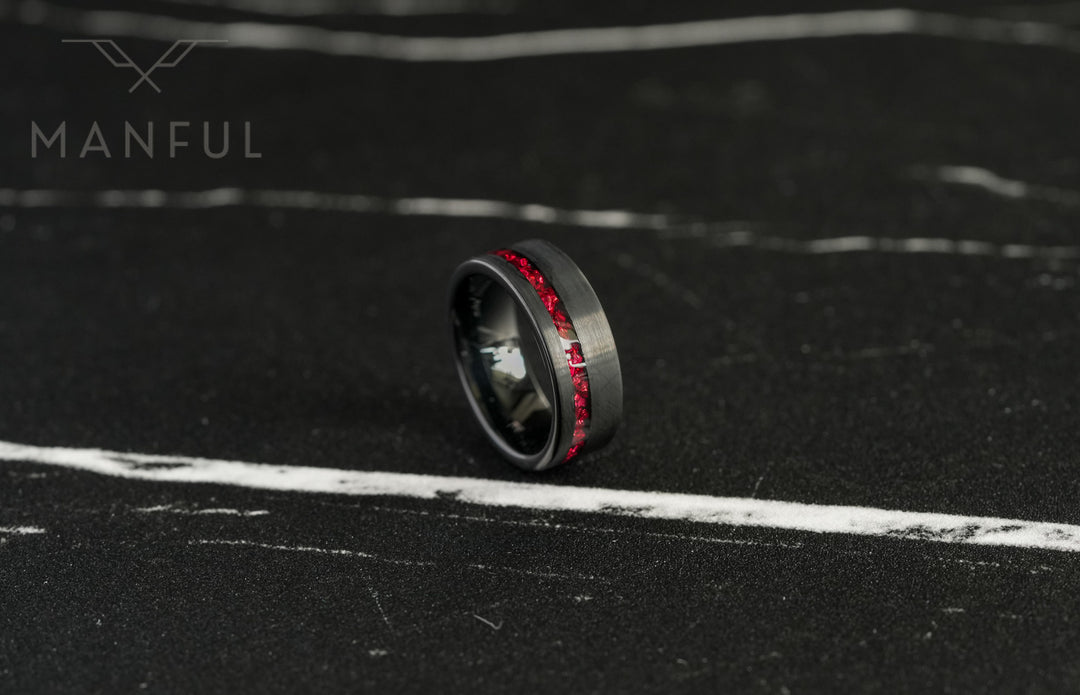 Tungsten Red Opal Inlay Band Black, tilted on a dark stone surface with the red inlay stripe close up