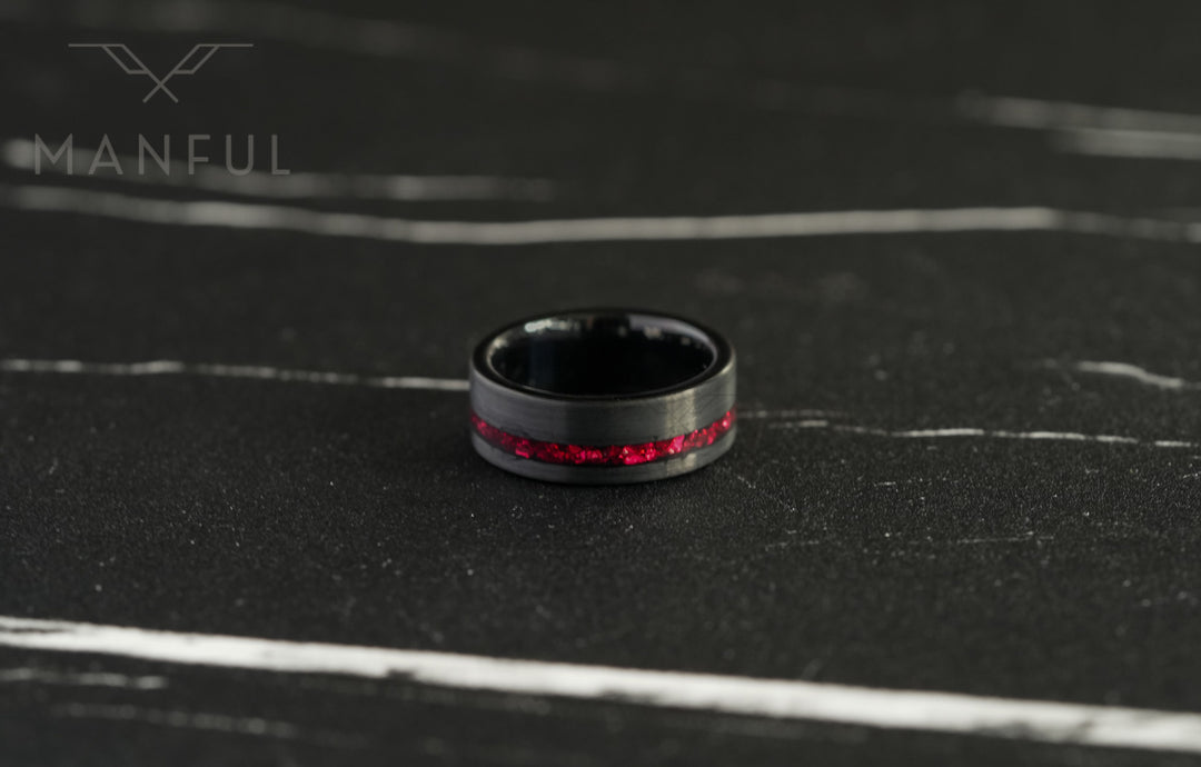 Tungsten Red Opal Inlay Band Black, resting flat on a dark marble surface with the red inlay facing forward
