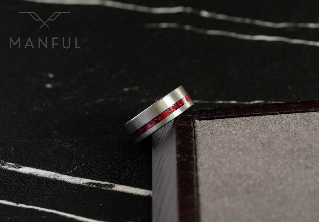 Tungsten Red Opal Inlay Band Silver, leaning against a dark box corner on marble showing the inlay
