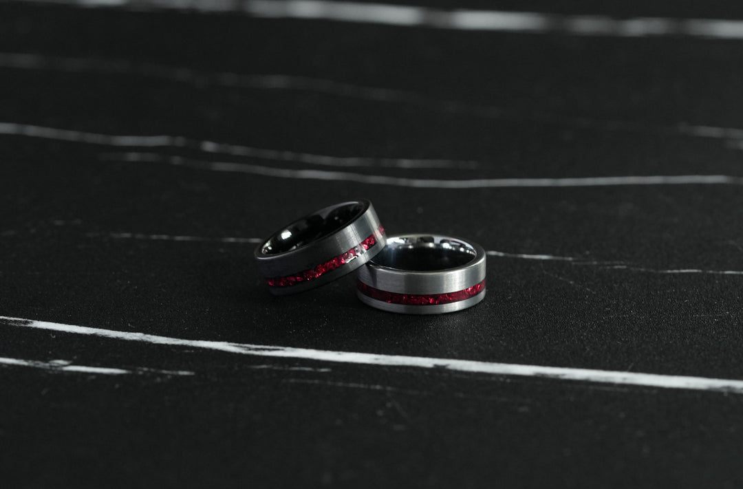 Tungsten Red Opal Inlay Band Black, paired with a second matching ring on a dark marble surface